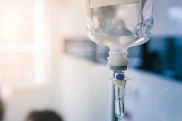 IV bag hanging in a hospital room, delivering fluids.