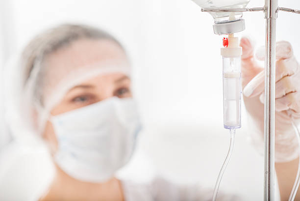 Nurse adjusting IV drip in a hospital setting.