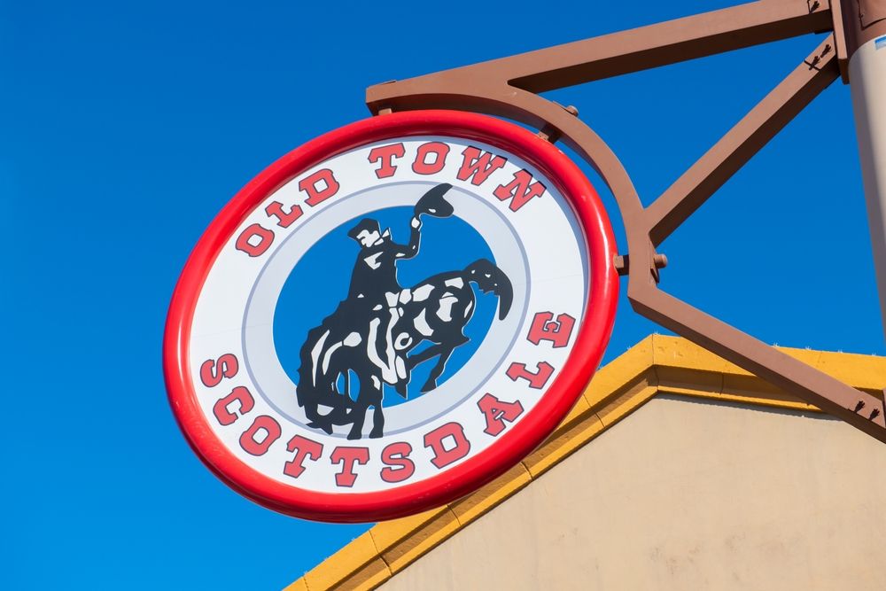 Old Town Scottsdale sign with a cowboy on a horse in a red-rimmed circle.