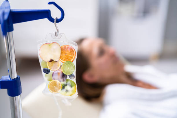 IV bag with fruit slices hanging over a person lying in a medical setting.