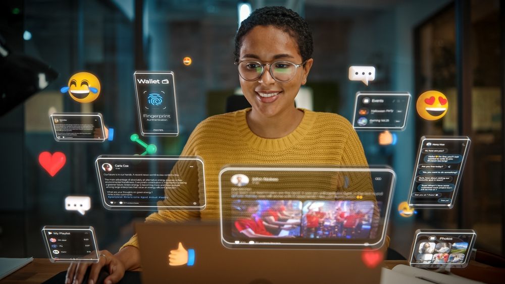 Woman smiling, using a laptop, surrounded by floating social media interfaces with emojis and notifications.