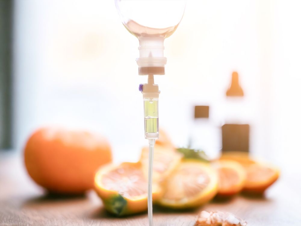 IV drip with oranges, promoting wellness. Focus on medical equipment and fruit.