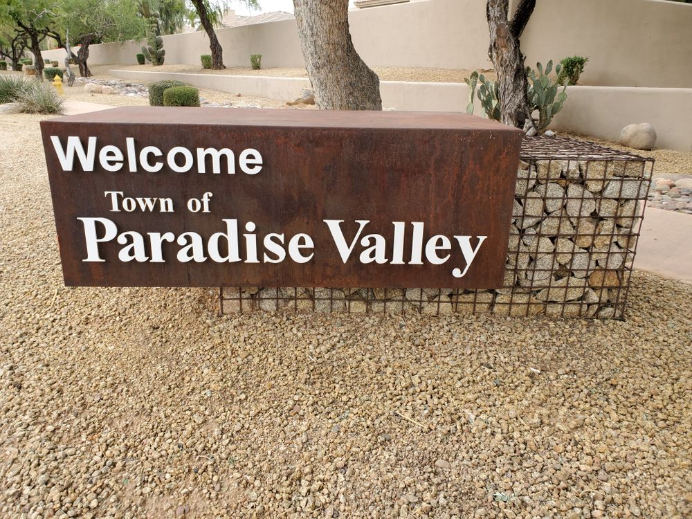 Welcome sign for Paradise Valley, Arizona, made of rusted metal.
