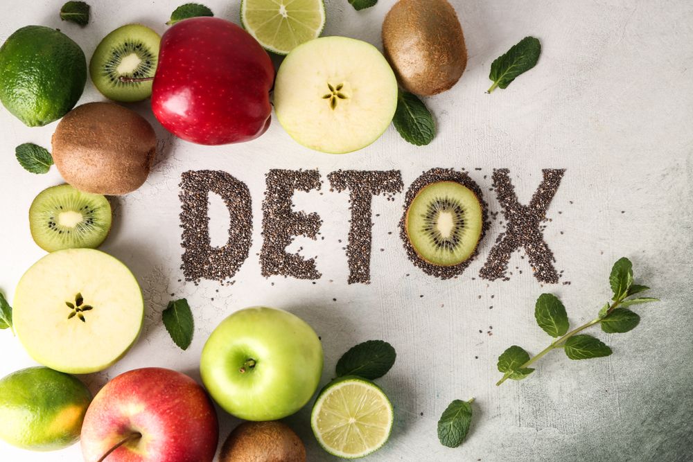 Fruits, including kiwi, apples, and limes, surround the word