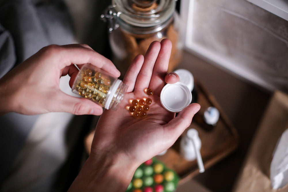 Person pouring pills from a bottle into their hand.