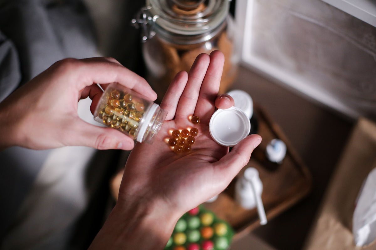 Person pouring pills from a bottle into their hand.