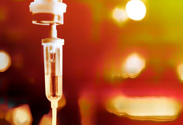 IV drip administering fluids against a blurred, warm-toned background.