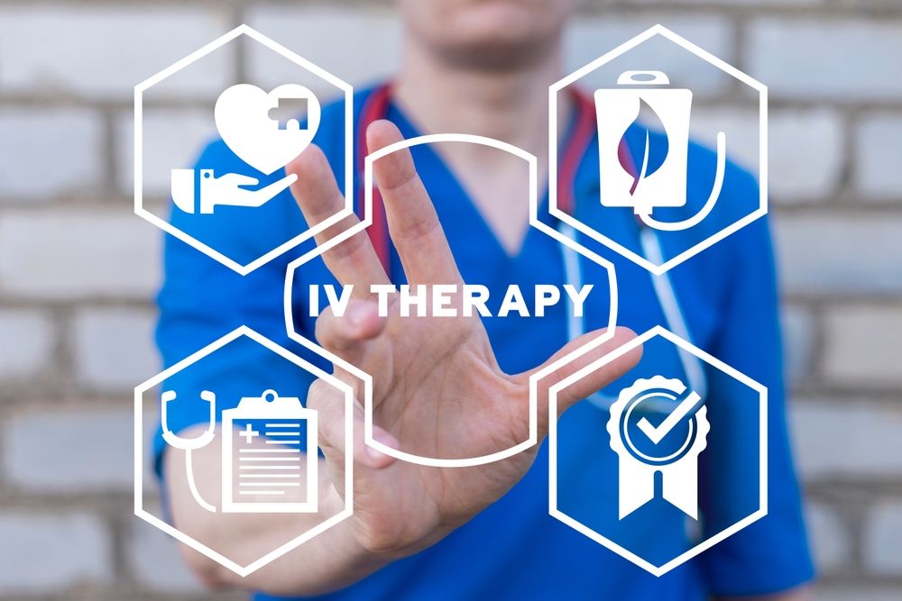 Doctor pointing at a diagram about IV therapy with icons like a heart, IV bag, and checklist.