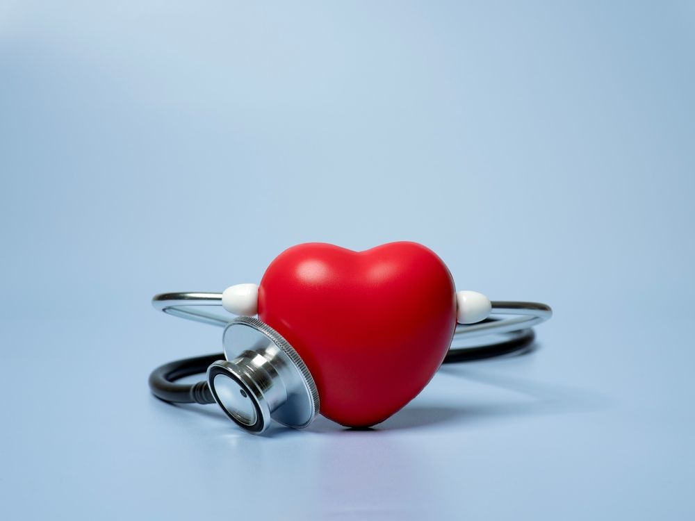 Red heart with stethoscope on blue background.