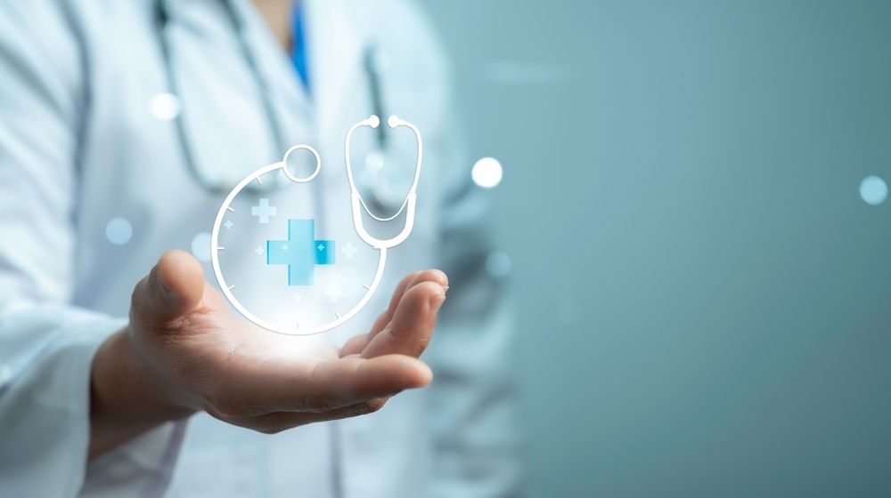 Doctor holding a glowing health symbol with stethoscope in hand.