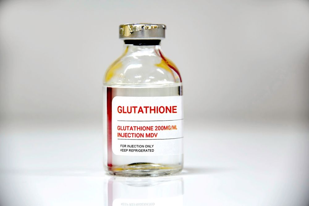 Vial of glutathione injection solution with a red and white label.