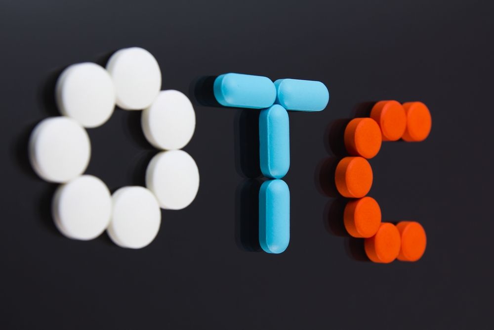 OTC spelled out with pills: white circle for