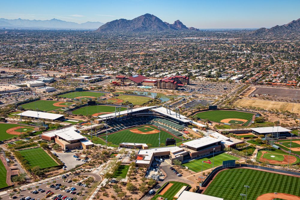 Aerial view of a baseball complex in a desert landscape with stadium and practice fields.