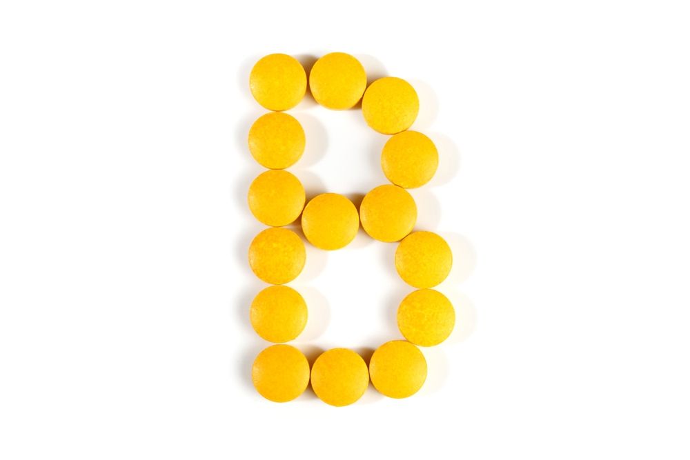 Yellow pills arranged in the shape of the letter